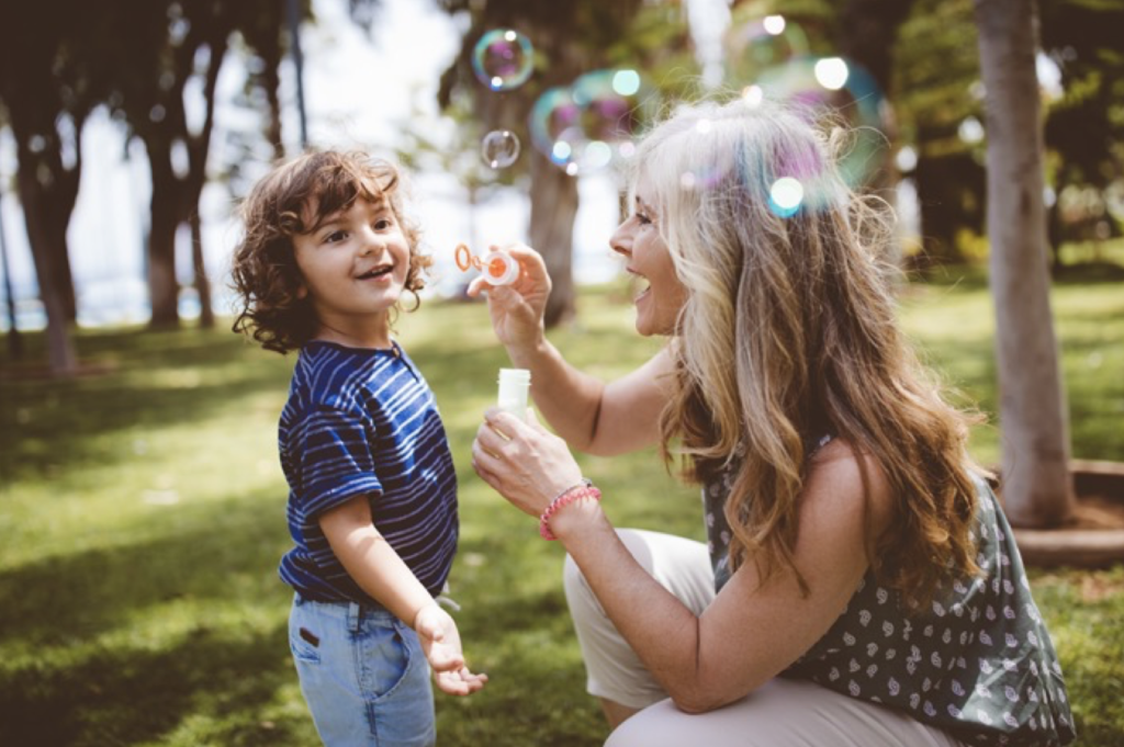 Image of a woman blowing bubbles with a young boy