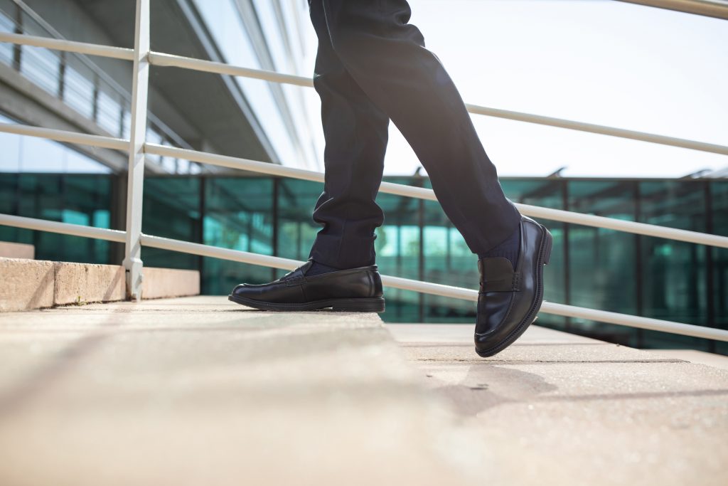 Cropped image of legs as professionally dressed person walks upstairs outside